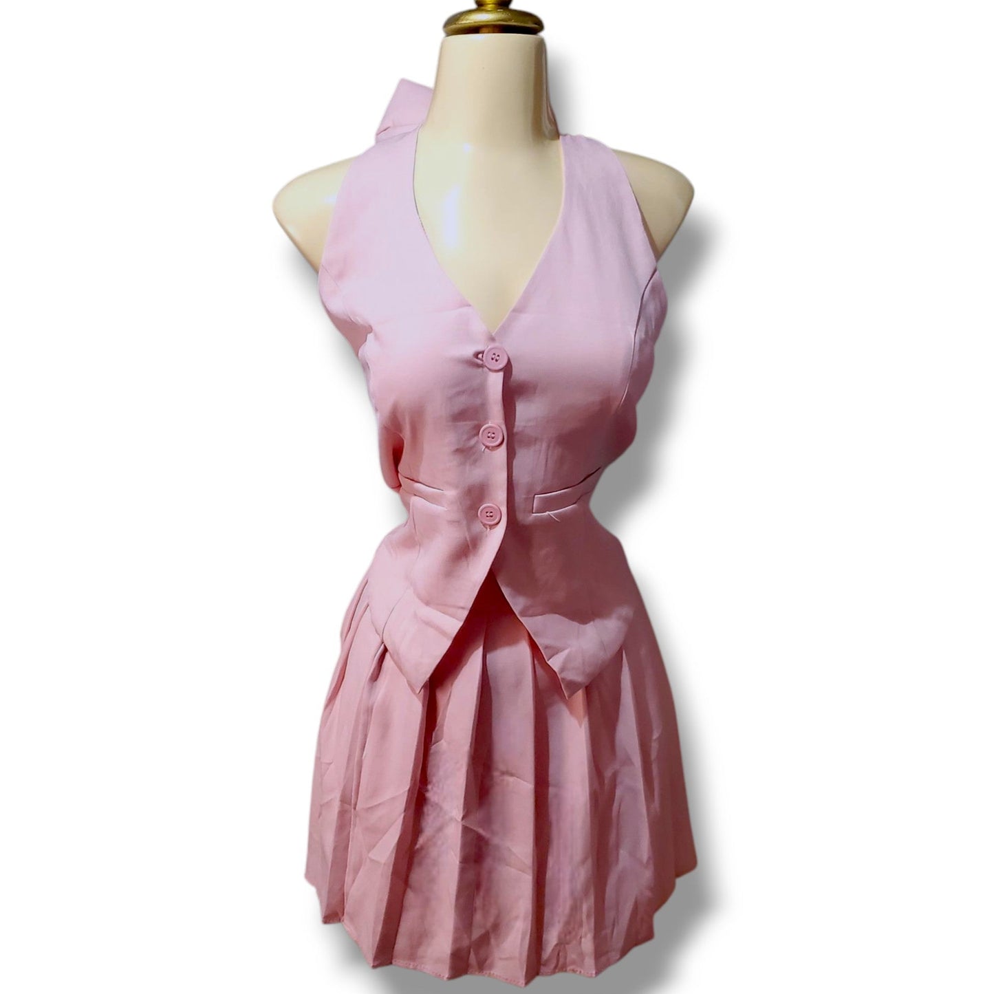 Conjunto juvenil con chaleco tipo halter y minifalda tableada – Detalle de moño en cuello