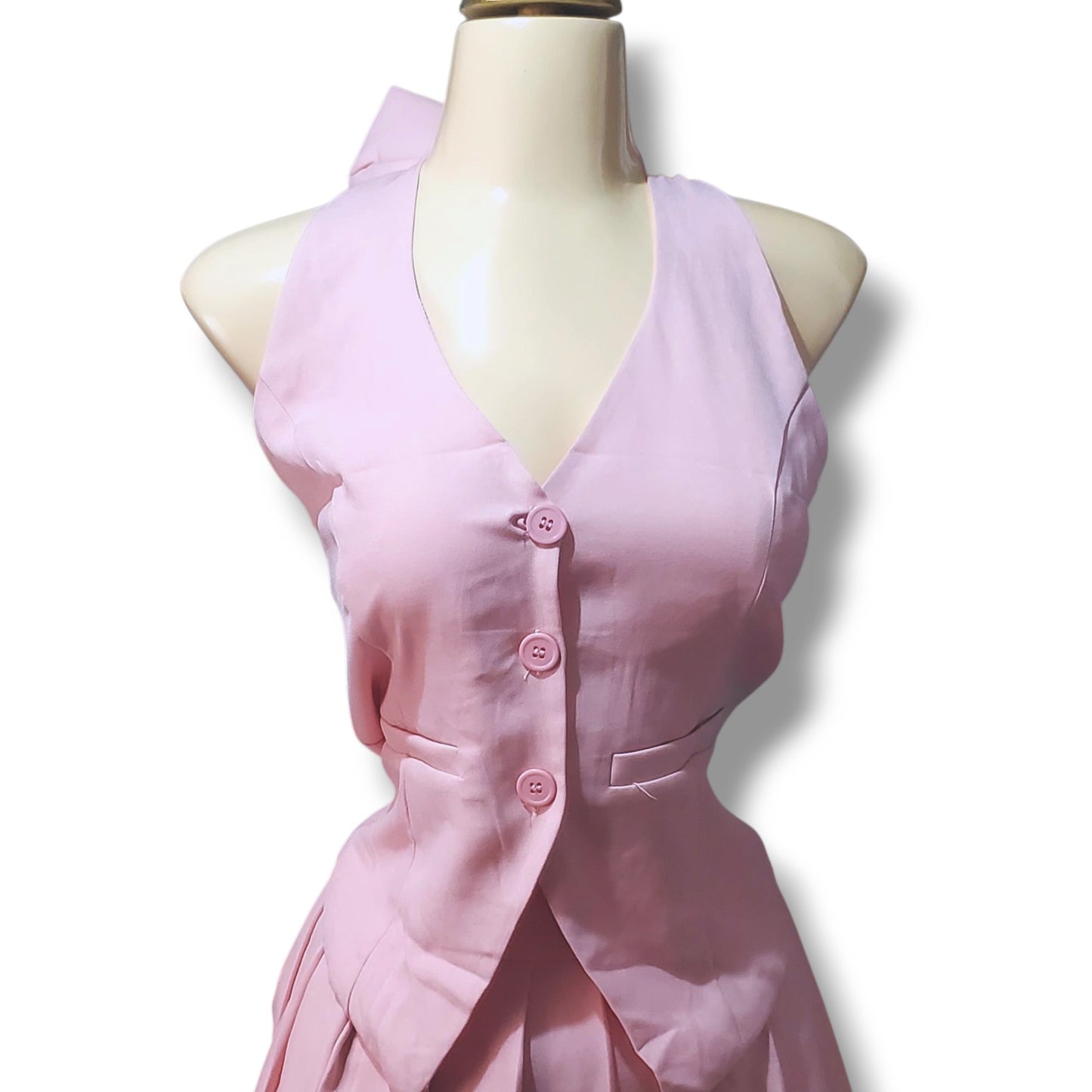 Conjunto juvenil con chaleco tipo halter y minifalda tableada – Detalle de moño en cuello